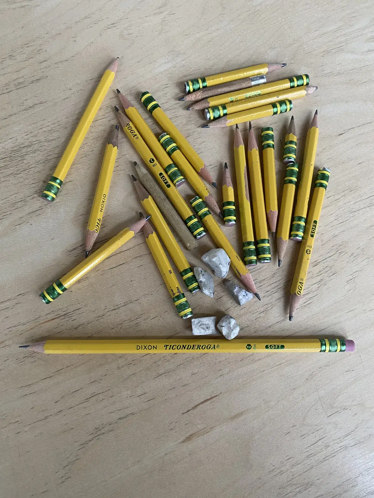 A pile of well-used pencils and erasers from daily handwriting practice