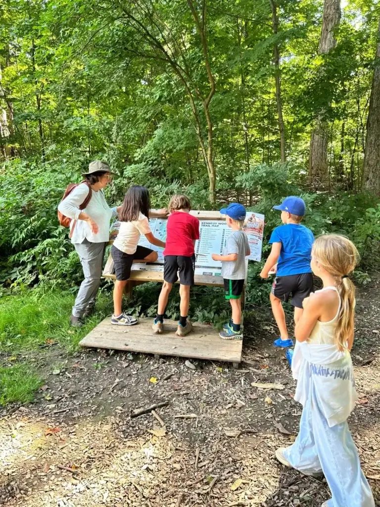 A teacher and students reading the Kennedy Woods trail map together
