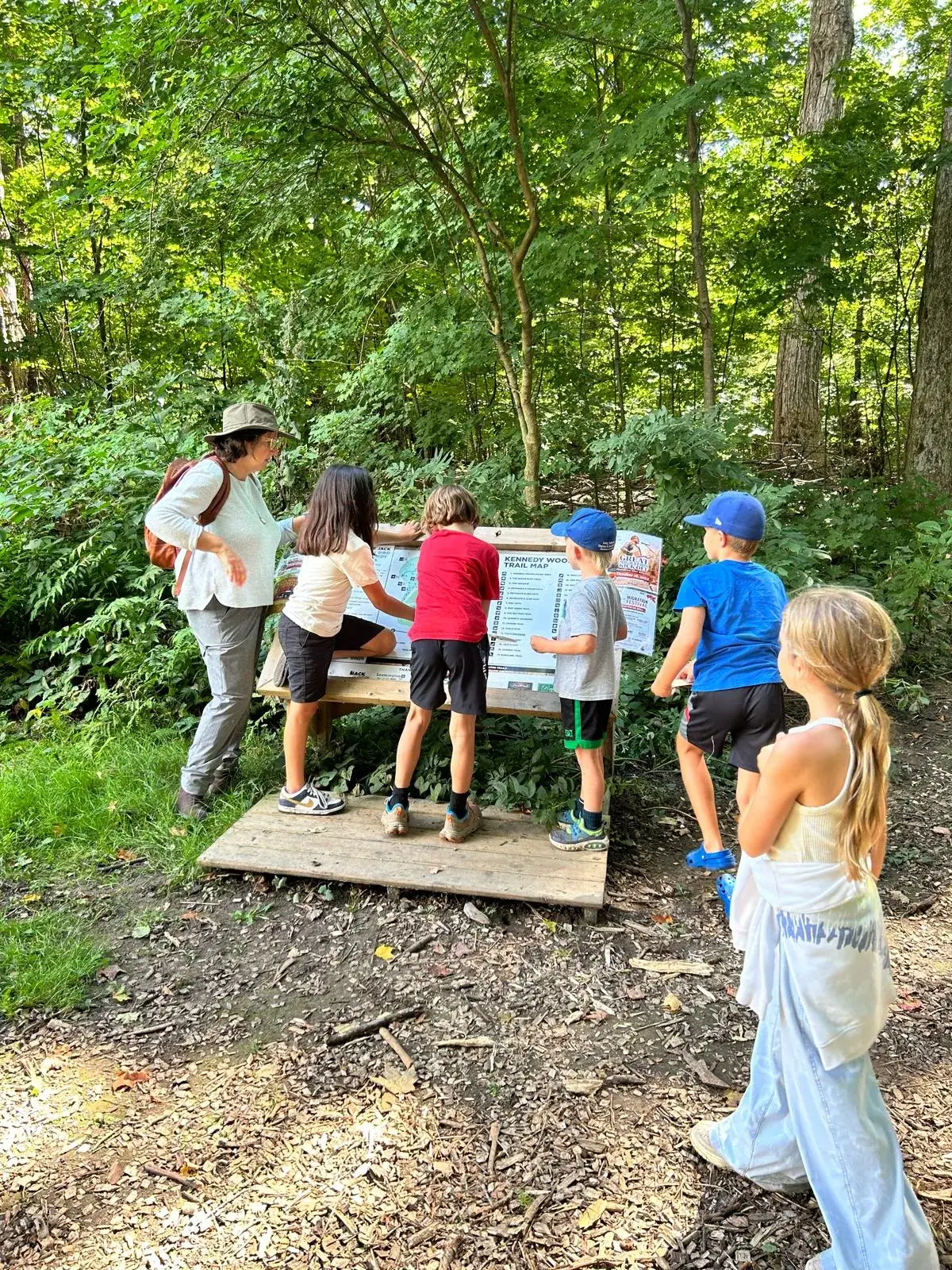 A teacher and students reading the Kennedy Woods trail map together